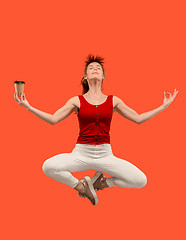 Image showing Freedom in moving. Pretty young woman jumping against orange background