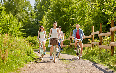 Image showing happy friends riding fixed gear bicycles in summer