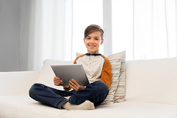 Image showing smiling boy with tablet pc computer at home