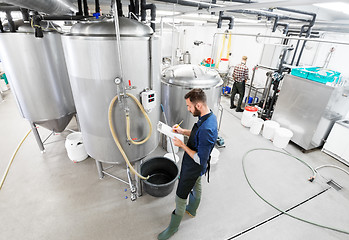 Image showing man with clipboard at craft brewery or beer plant