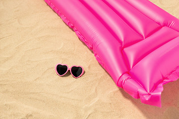 Image showing sunglasses and pink swimming mattress on beach