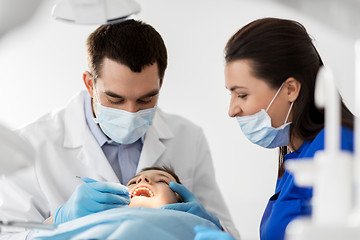 Image showing dentist checking for kid teeth at dental clinic