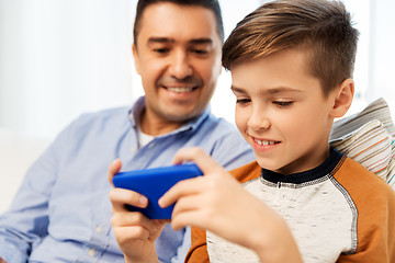 Image showing happy father and son with smartphone at home