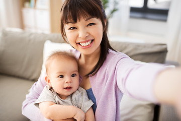 Image showing asian mother with baby son taking selfie at home