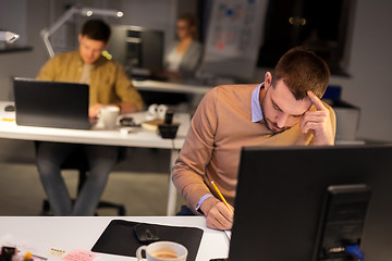 Image showing man with computer working late at night office