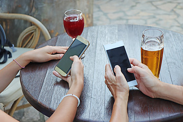 Image showing Two young girls watching smart mobile phones