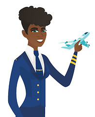 Image showing Young african stewardess with model of airplane.