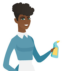 Image showing Young african cleaner in uniform holding detergent