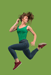 Image showing Freedom in moving. Pretty young woman jumping against orange background