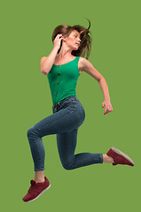 Image showing Freedom in moving. Pretty young woman jumping against orange background