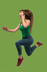 Image showing Full length of pretty young woman with mobile phone while jumping