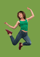 Image showing Freedom in moving. Pretty young woman jumping against orange background