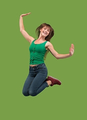 Image showing Freedom in moving. Pretty young woman jumping against orange background