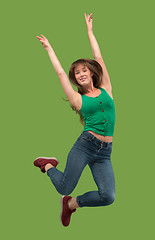 Image showing Freedom in moving. Pretty young woman jumping against orange background