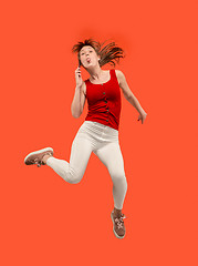 Image showing Full length of pretty young woman with mobile phone while jumping