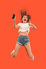 Image showing Full length of pretty young woman with mobile phone while jumping