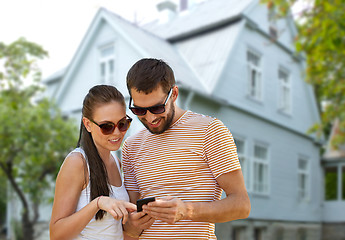 Image showing happy couple with smartphone in summer over house