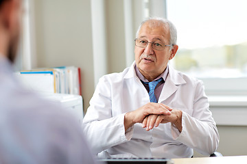 Image showing senior doctor talking to male patient at hospital