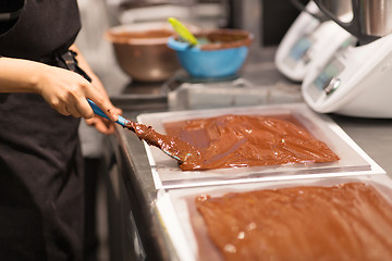 Image showing confectioner makes chocolate dessert at sweet-shop