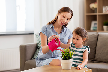 Image showing pregnant mother and daughter watering home plant