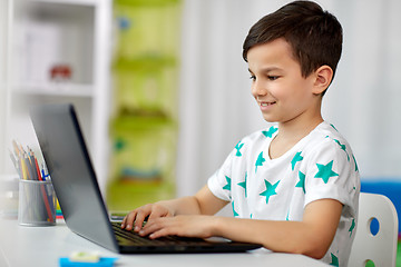 Image showing student boy typing on laptop computer at home