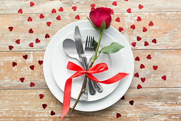 Image showing close up of red rose flower on set of dishes