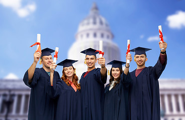 Image showing graduates in mortar boards with diplomas
