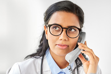 Image showing doctor in glasses calling on phone at hospital