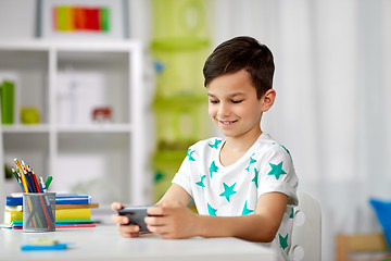 Image showing happy boy with smartphone at home