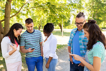 Image showing happy friends with smartphones at summer park