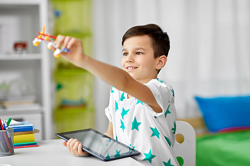Image showing boy with tablet computer and toy airplane at home