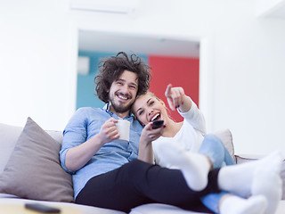 Image showing Young couple on the sofa watching television