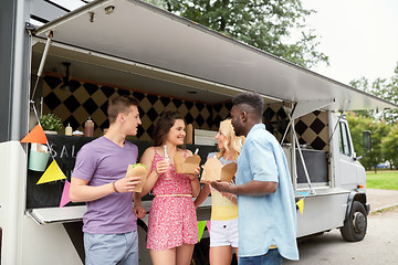 Image showing happy friends with drinks eating at food truck