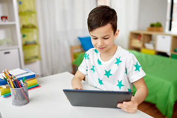 Image showing student boy with tablet pc and notebook at home