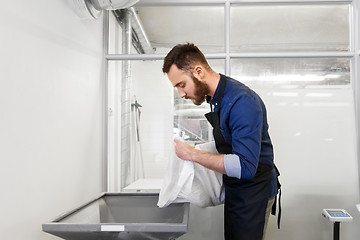 Image showing brewer pouring malt into mill at beer brewery