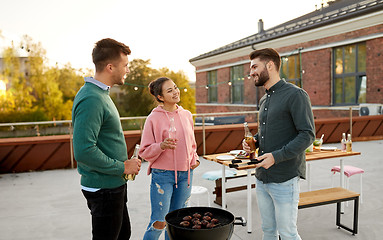 Image showing happy friends having bbq party on rooftop