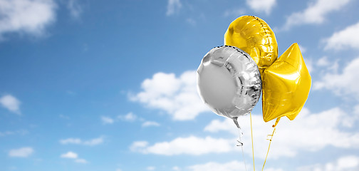 Image showing three gold and silver helium balloons on white