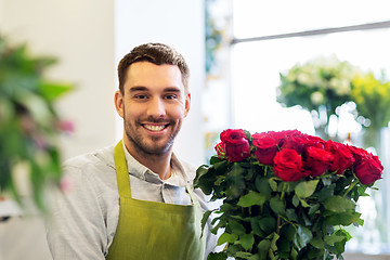 Image showing florist or seller with red roses at flower shop