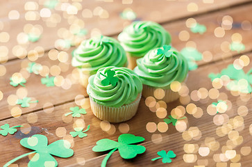 Image showing green cupcakes and shamrock on wooden table