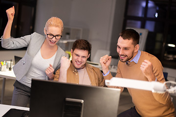 Image showing business team celebrating success at night office