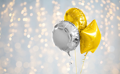 Image showing three gold and silver helium balloons on white
