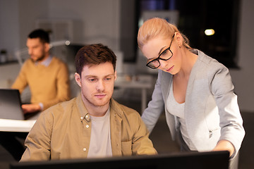 Image showing business team with computer working late at office