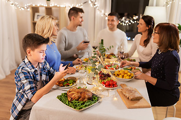 Image showing boy with smartphone at family dinner party