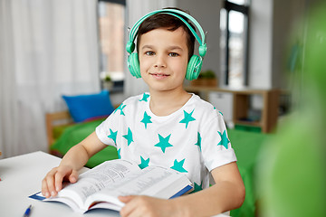 Image showing boy in headphones with textbook learning at home