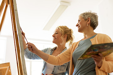 Image showing women with brushes painting at art school