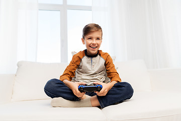 Image showing happy boy with gamepad playing video game at home