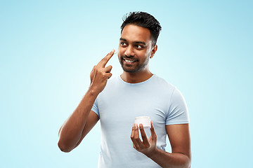 Image showing happy indian man applying cream to face