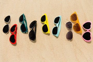 Image showing different sunglasses on beach sand