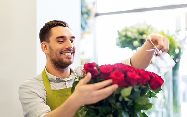 Image showing florist or seller setting red roses at flower shop