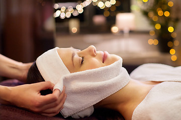 Image showing woman having face massage with towel at spa